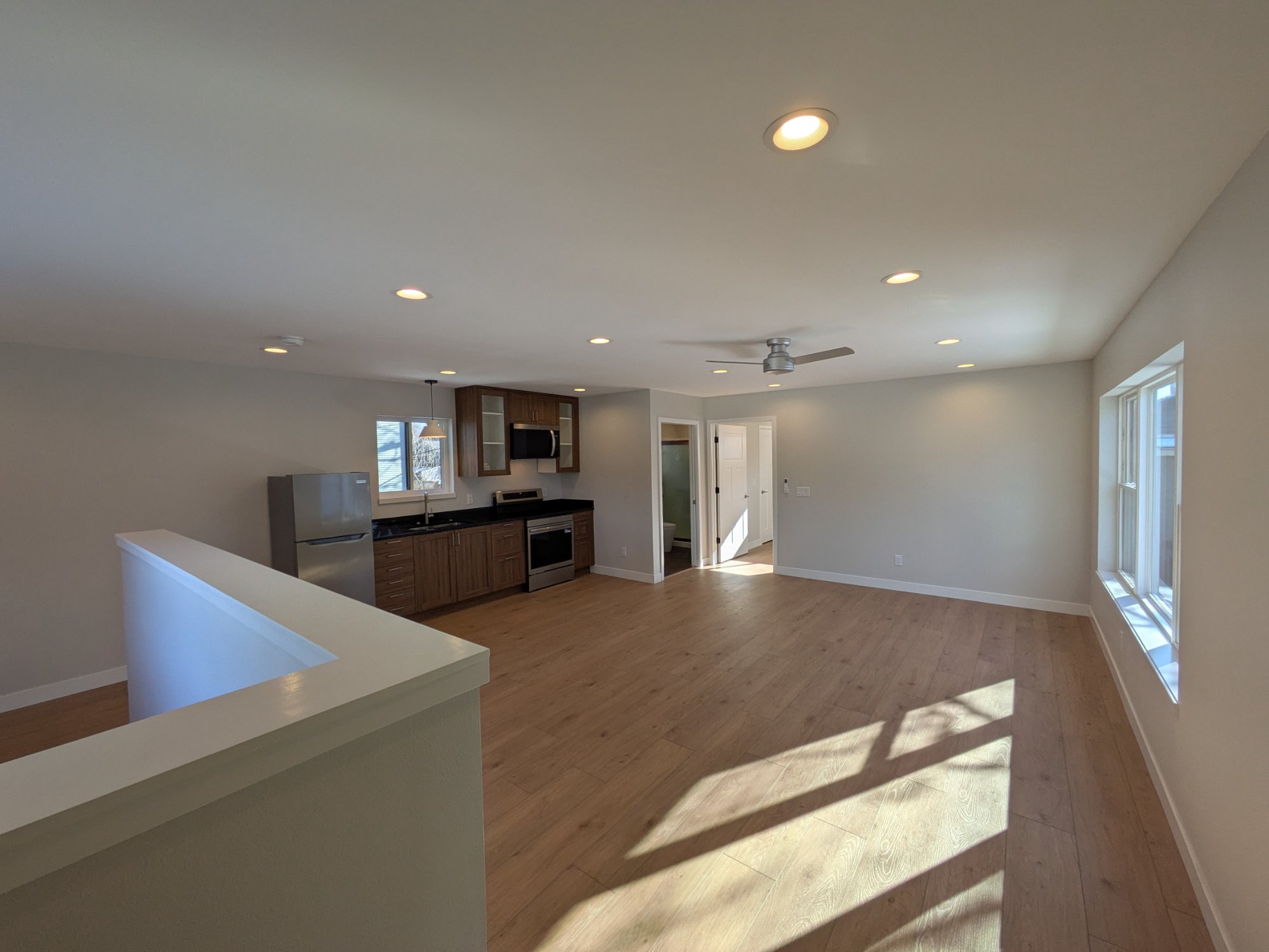 Upper landing with large window and open stair rail — finished ADU interior Madison WI