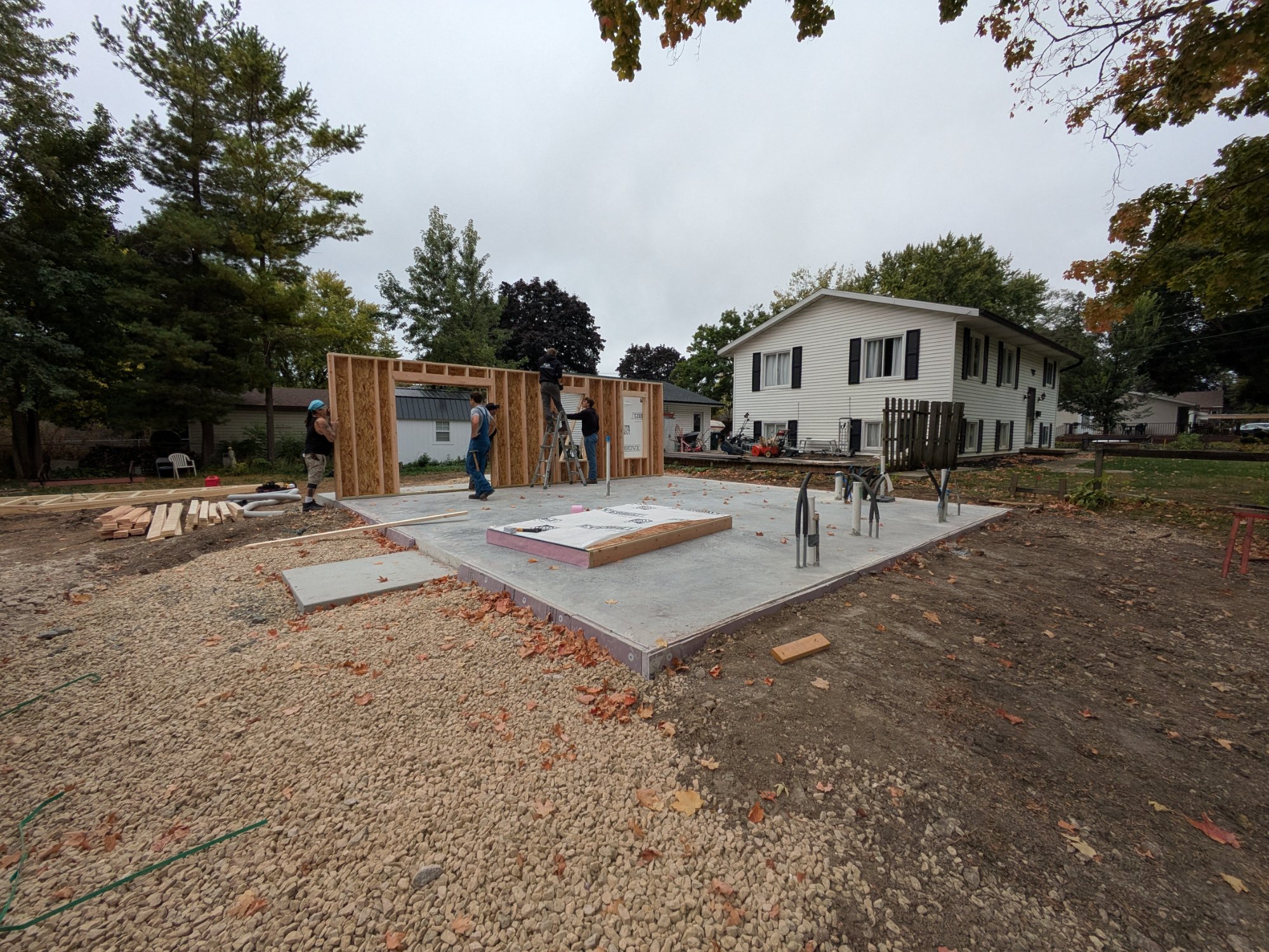 Crew raising first wall panels off slab — day one framing, North Side ADU Madison WI, October 2025