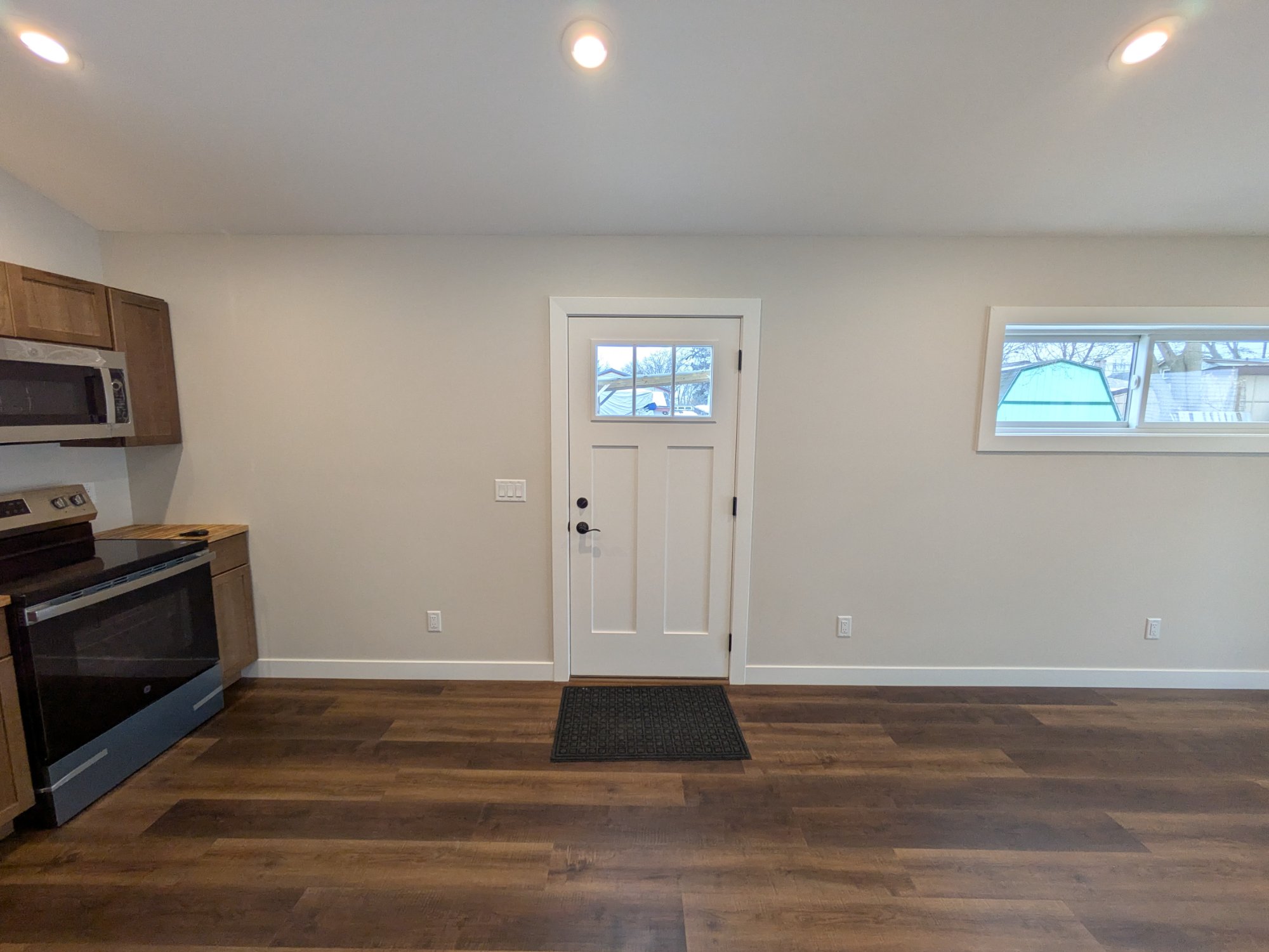 Kitchen with stainless appliances, wood cabinets, craftsman side entry — North Side ADU Madison WI