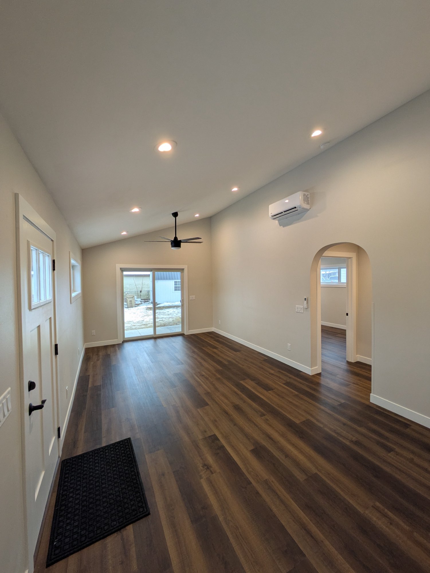 Finished living area — vaulted ceiling, custom archway to hallway, mini-split, slider to covered patio — North Side ADU Madison WI