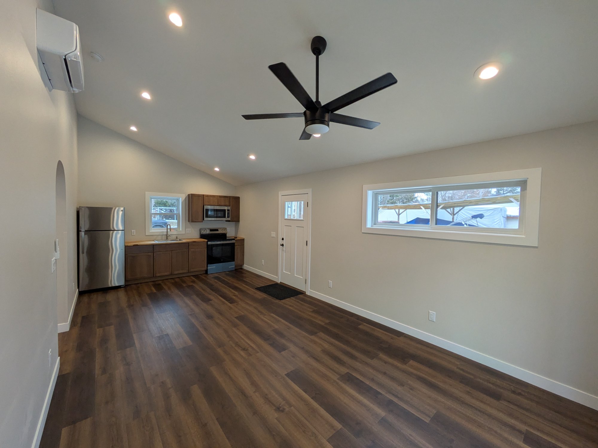 Living area looking toward open kitchen — dark LVP, fan, mini-split — North Side ADU Madison WI